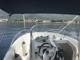 A view of the helm and console inside a boat, showcasing the steering wheel and controls, perfect for navigating the serene waters.