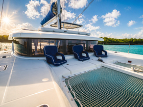A serene view of the lounge area on a luxurious catamaran, featuring comfortable seating and stunning ocean views, perfect for relaxation while cruising.