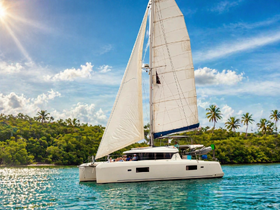 A stunning catamaran sails through crystal-clear waters, surrounded by lush greenery and a bright blue sky — perfect for tropical adventures.