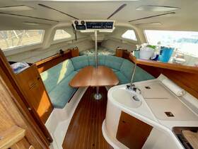 A cozy interior view of a boat cabin featuring comfortable seating and a well-equipped helm area, perfect for relaxing during a sailing trip.