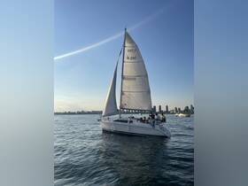 A lively group enjoys a sailing experience on a beautiful day, with a stunning city skyline in the background.