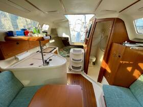 Interior view of a cozy boat cabin featuring a well-equipped galley and comfortable seating, perfect for relaxing during a day on the water.