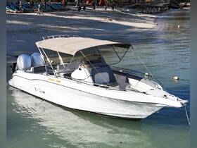 A sleek speedboat named 'Ti Tom' docked in clear waters, showcasing its stylish design and inviting seating, perfect for a day on the water.