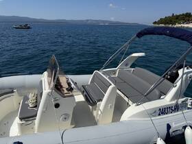 A detailed view of the interior helm and seating area of a boat, showcasing comfortable seating and a well-equipped console, perfect for day trips on the water.