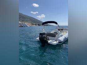 A sleek speedboat with a Suzuki outboard motor glides through clear waters, showcasing the stunning coastal scenery in the background.