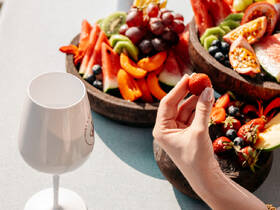 A beautifully arranged platter of fresh fruit and a cocktail glass, perfect for enjoying a luxurious day on the water. Ideal for catering and onboard dining experiences.