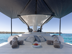 A serene setup on a boat featuring plush towels and a bowl of fresh fruit, perfect for a relaxing day on the water.
