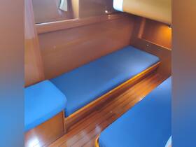 Interior view of a cozy boat cabin featuring comfortable blue seating, perfect for relaxation during your nautical adventures.