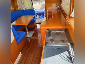 Interior view of a boat's cabin featuring comfortable blue seating and a dining area, perfect for relaxing and enjoying meals while on the water.