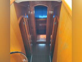 Interior view of a boat cabin showcasing polished wood finishes and a cozy seating area, perfect for relaxation while on the water.