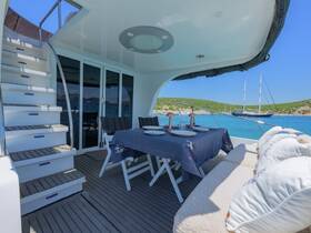 A beautifully arranged dining area inside a yacht, featuring elegant table settings and a view of the serene waters, perfect for enjoying meals while cruising.