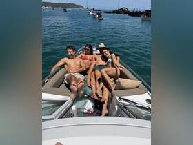 A fun group of friends relaxes on the deck of a boat, enjoying the sun and water — perfect for a day of celebration and camaraderie.