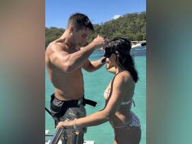 A couple prepares for snorkeling in crystal-clear waters, showcasing the excitement of underwater adventures and shared experiences on a boat trip.