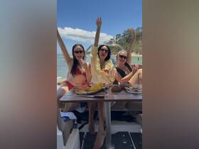 A lively group of friends celebrates on a boat with delicious food and drinks, enjoying a perfect day on the water.