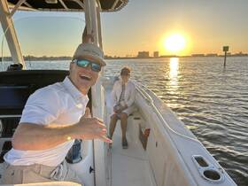 A joyful moment captured at sunset on a boat, showcasing a couple enjoying their time on the water — perfect for romantic outings or sunset cruises.