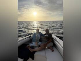 A couple enjoys a serene sunset on a boat, creating a perfect backdrop for romantic moments and memorable experiences on the water.