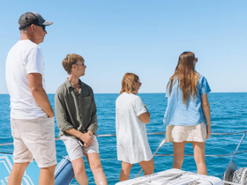 A group of friends enjoys the ocean view from the deck of a boat, capturing the essence of a perfect day on the water.