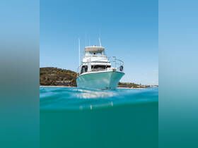 A stunning view of a yacht captured from below the water's surface, showcasing its sleek design against a clear blue sky — perfect for luxury boating experiences.