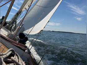 A dynamic shot of a sailboat underway, capturing the sails in action and the excitement of sailing on open waters.