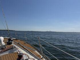 A scenic view from the deck of a sailboat, showcasing the calm waters and distant bridges under a clear blue sky — perfect for sailing enthusiasts and adventure seekers.