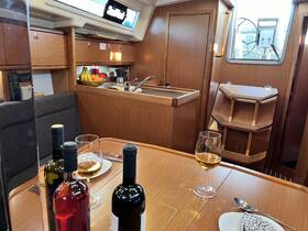A cozy interior view of a boat's dining area, featuring a well-equipped kitchen and a beautifully set table with wine, perfect for intimate meals on the water.