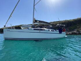 A stunning sailboat anchored in crystal-clear waters, showcasing its sleek design against a backdrop of lush greenery.