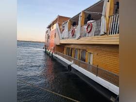 A side view of a beautifully designed boat docked at the pier, showcasing its wooden structure and inviting ambiance.