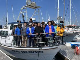A cheerful group poses on the deck of the 'Bog Heaven' boat, ready for an exciting day on the water. Perfect for group outings and celebrations.
