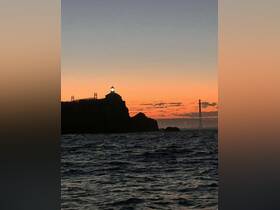 A stunning sunset view featuring a lighthouse silhouetted against the vibrant sky, perfect for capturing the beauty of coastal adventures.