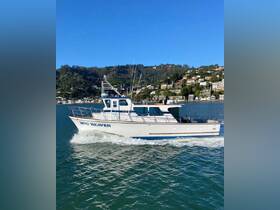 The 'Hog Heaven' boat glides through the water, showcasing its sleek design against a picturesque backdrop of hills and homes.