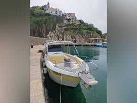 A sleek speedboat docked in a picturesque harbor, surrounded by rocky cliffs and charming buildings, perfect for exploring coastal destinations.