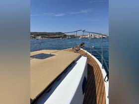 A clear view of the bow of a yacht, showcasing its elegant design and wooden deck, set against a tranquil harbor backdrop.