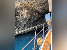 A scenic view from a boat navigating through a rocky cave, showcasing the stunning coastline and vibrant blue waters — perfect for adventure seekers exploring hidden gems.