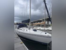 A sleek sailboat docked at the marina, showcasing its elegant design against a backdrop of overcast skies.