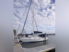A beautiful sailboat docked at the marina, showcasing its elegant design against a backdrop of cloudy skies — perfect for sailing enthusiasts and boat lovers.