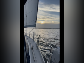 A serene view of a sailboat gliding through calm waters at sunset, showcasing the beauty of sailing and the tranquility of the open sea.