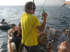 A lively group enjoys drinks aboard a sailboat, capturing the essence of a fun day on the water with friends.