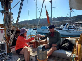 A couple enjoys a toast aboard a sailboat, surrounded by stunning views of the marina — a perfect moment for relaxation and celebration on the water.