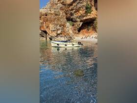 A serene view of a small boat anchored in clear waters near a rocky shoreline, perfect for exploring hidden coves and enjoying nature.