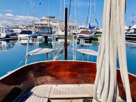 A serene view from the bow of a boat in a marina, showcasing a variety of yachts and sailboats docked in calm waters — perfect for a day of leisure on the water.