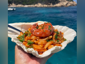 A delicious plate of seafood pasta served in a shell, perfect for enjoying a gourmet meal on the water. Ideal for catering options during boat trips.