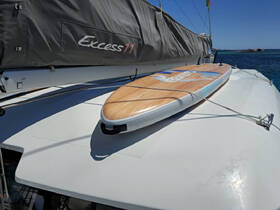 A paddleboard rests on the deck of a catamaran, showcasing the perfect water toy for fun and adventure during a sailing trip.