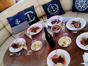 An elegant dining setup featuring gourmet dishes and champagne on a yacht, perfect for luxurious onboard meals and celebrations.