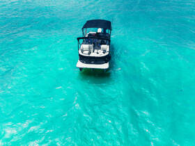 Aerial view of a sleek speedboat cruising through crystal-clear turquoise waters, perfect for summer adventures and water sports.