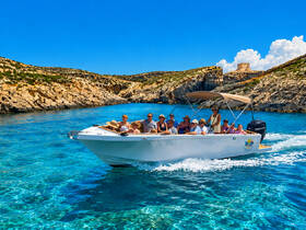 A lively group enjoys a scenic boat ride through crystal-clear waters, surrounded by stunning coastal landscapes — perfect for family outings and adventures.