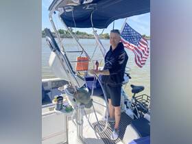 A man stands at the helm of a boat, showcasing the interior features including the steering console and seating area. Ideal for those looking to navigate the waters in style.
