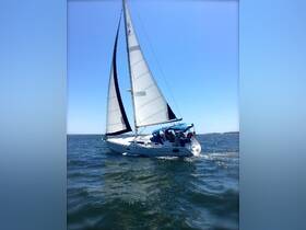 A beautiful sailboat glides through the water under full sail, showcasing its elegant design and the thrill of sailing on a clear day.