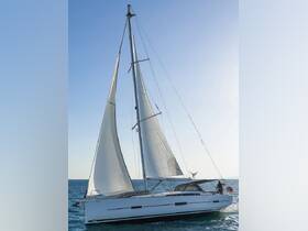 A sleek sailboat glides through the water, showcasing its elegant design and sails against a clear blue sky — perfect for sailing enthusiasts and charters.
