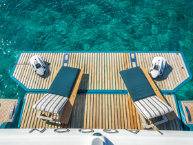 A serene view of a sunbed on a boat deck, perfect for lounging under the sun while enjoying the clear turquoise waters.