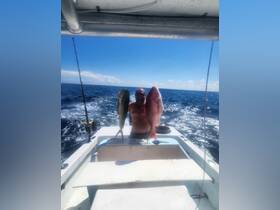 A proud angler displays his impressive catch of fish while aboard a boat in the open ocean, showcasing the thrill of deep-sea fishing.